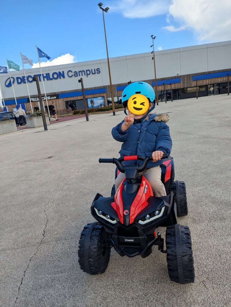 Mon fils et son quad électrique devant Decathlon — signe de victoire 🤙