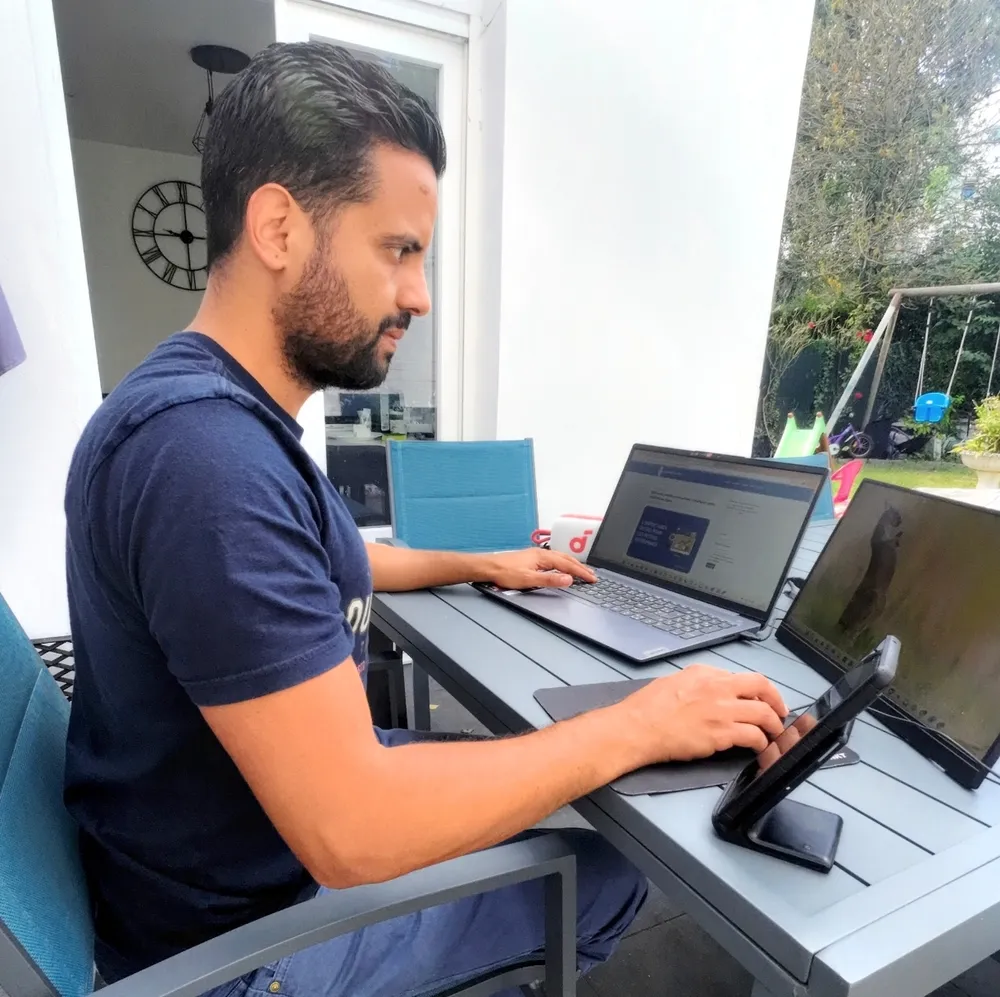 Younès en train de tester un ordinateur et un écran portable sur sa terrasse